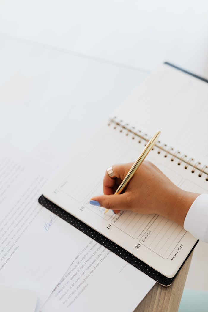 Elegant hand writing plans in a notebook with a pen, perfect for organization themes.